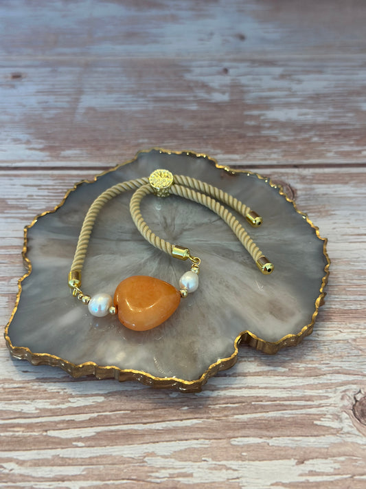 Pulseras en cordón beige con dije de 🧡 Ámbar