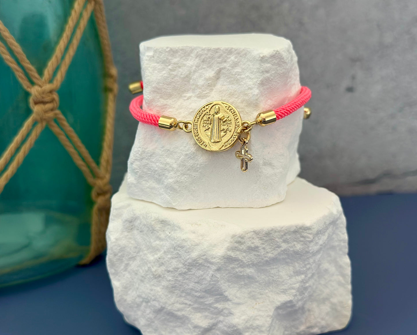 A- Pulseras de cordón con dijes de San Benito y Cruz