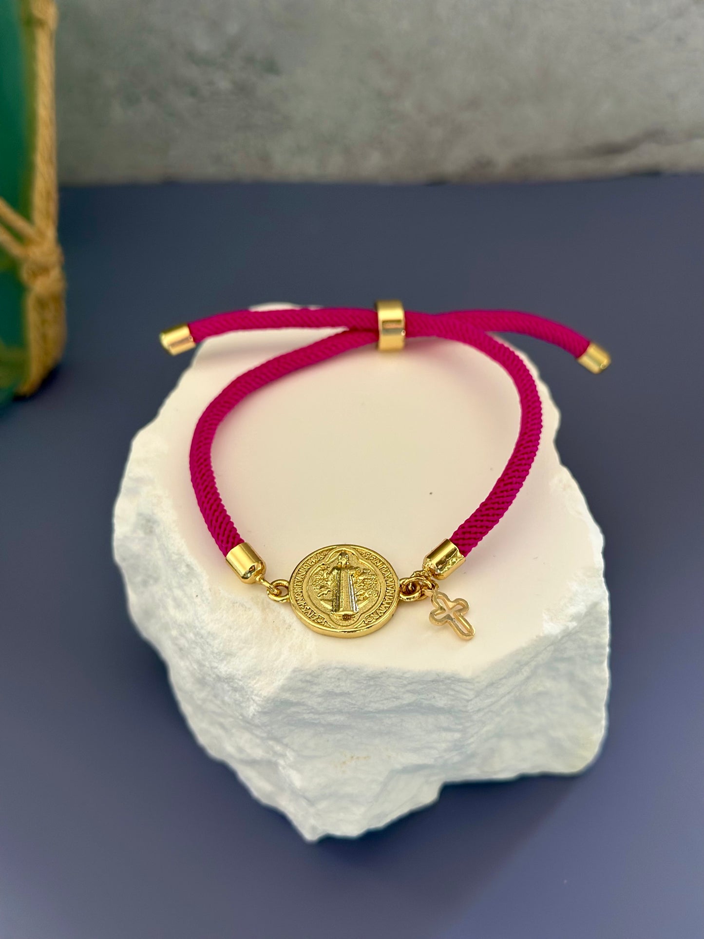A- Pulseras de cordón con dijes de San Benito y Cruz