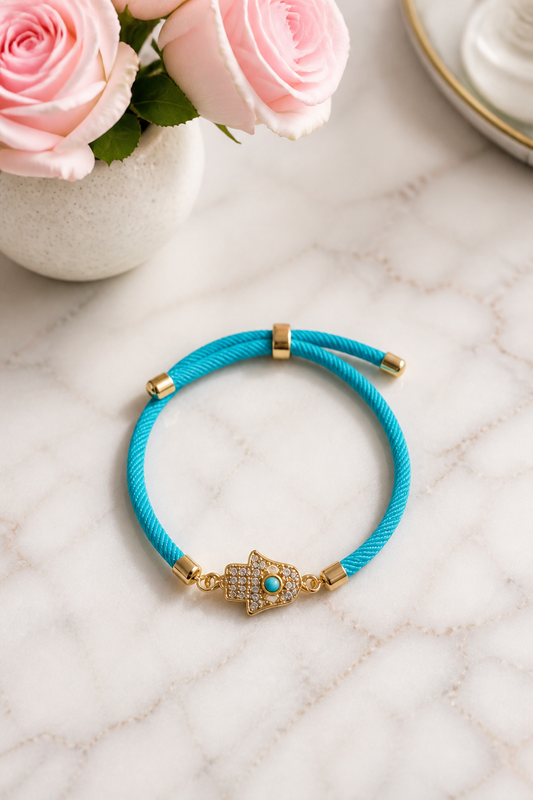 A Pulsera en cordón celeste con dije de mano 🧿